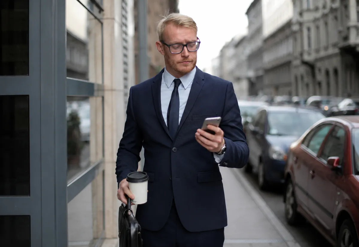 Sælger tjekker dagens opfølgninger på mobilen mellem to møder
